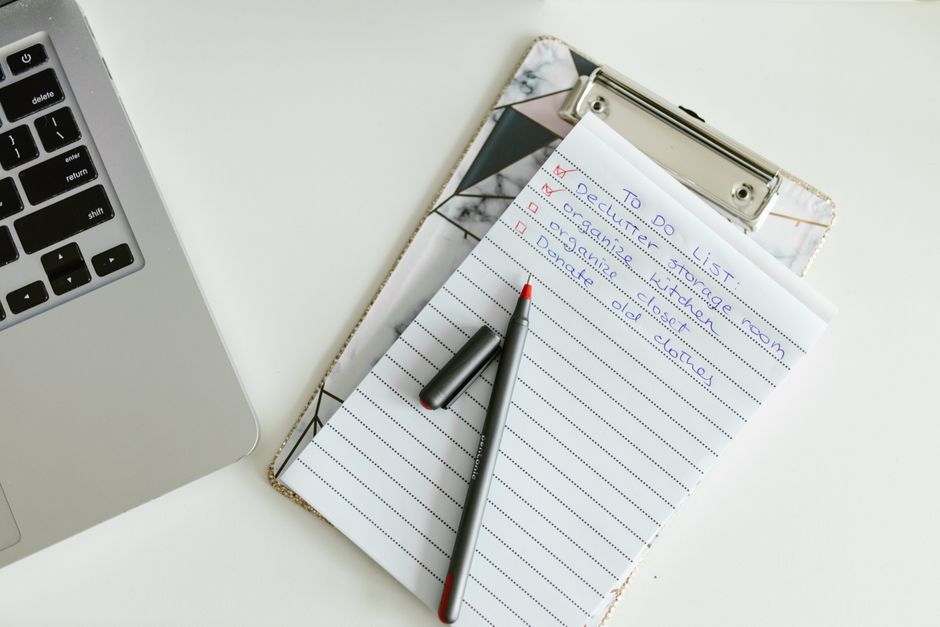 Draufsicht auf einen Schreibtisch mit Checkliste, Laptop und Notizblock – abstrakte Planungsszene ohne erkennbare Person